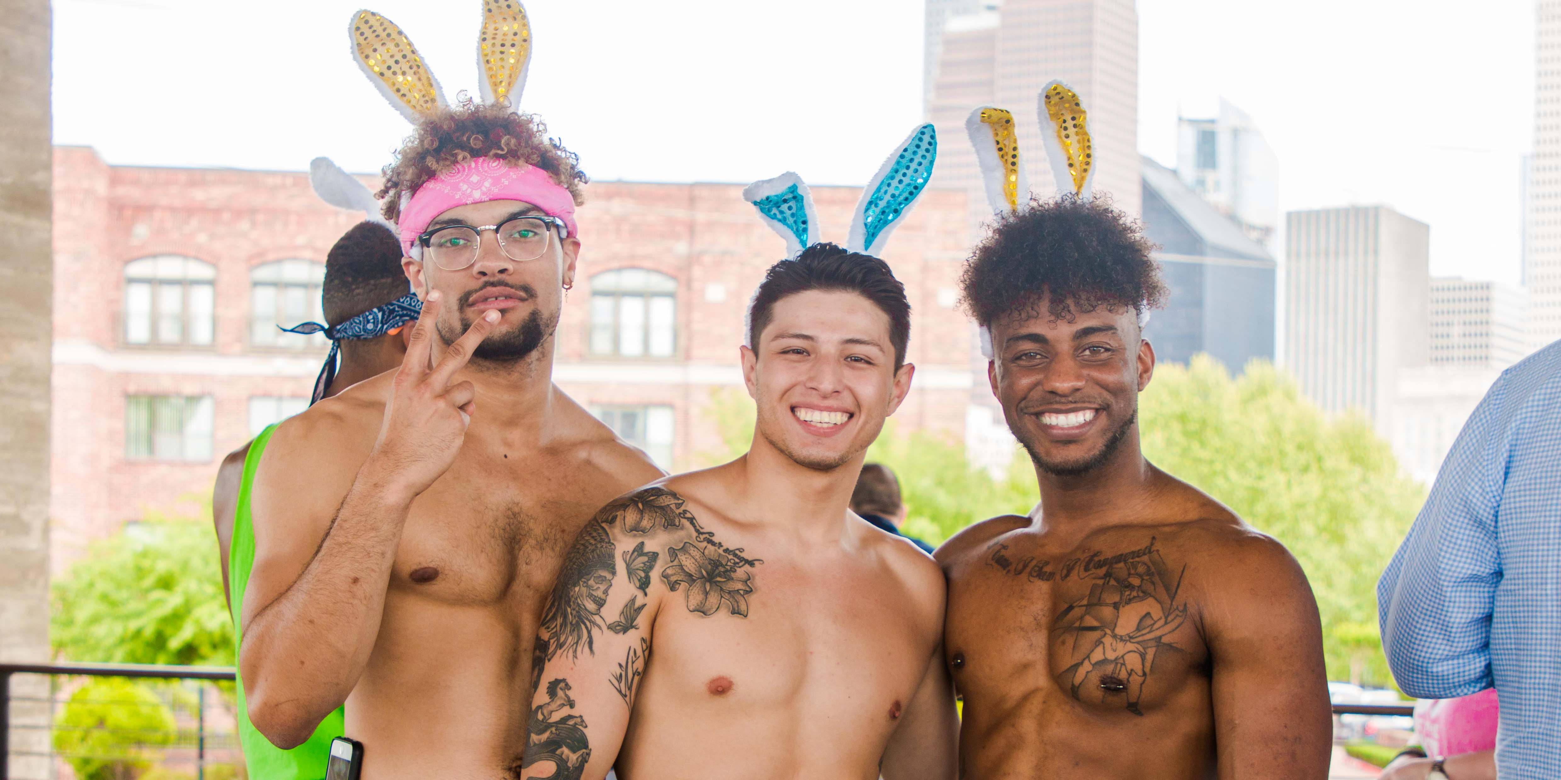 23 shirtless hunk wearing bunny ears and over-the-top Easter bonnets